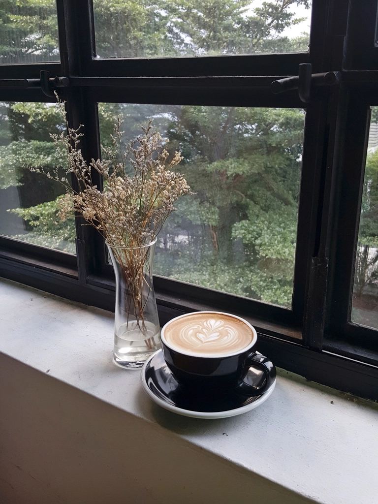 窓辺の席に置かれたカフェラテ