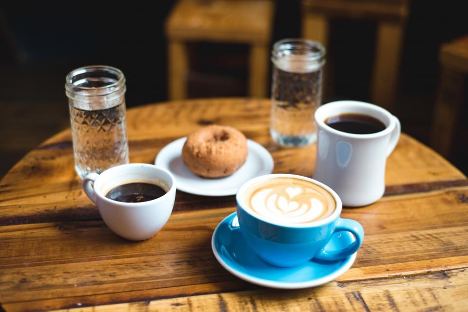木のテーブルに並ぶコーヒー